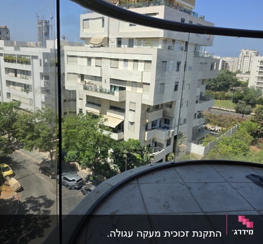 מעקה זכוכית במרפסת עם נוף לעיר